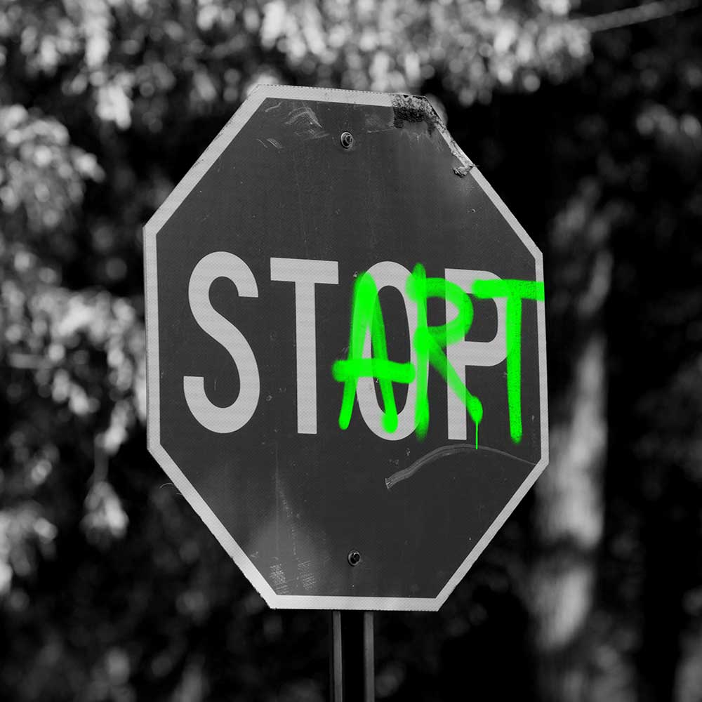 Ein Stop-Schild, übersprüht mit grüner Sprühfarbe.